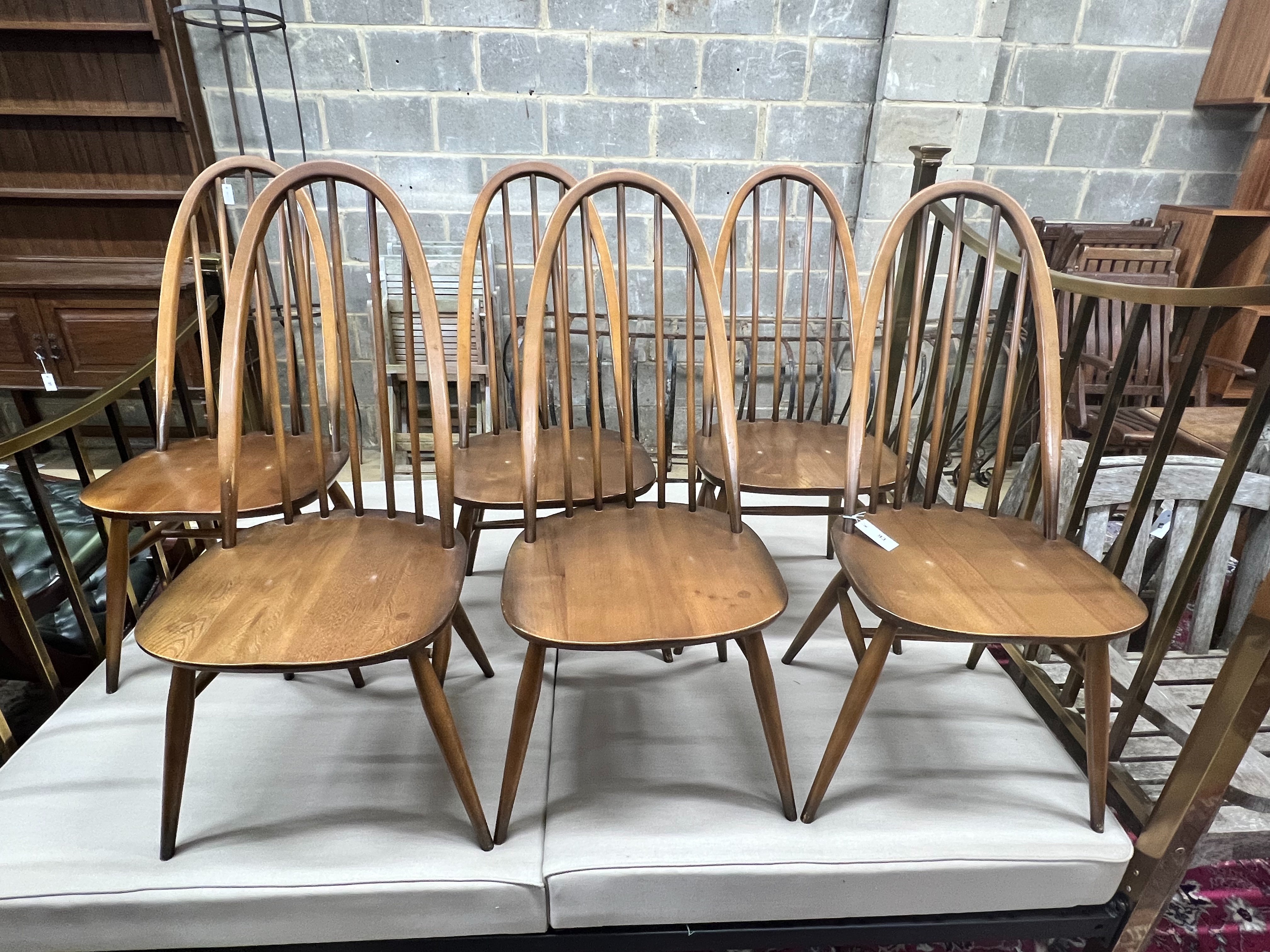 A set of six Ercol elm and beech comb back dining chairs